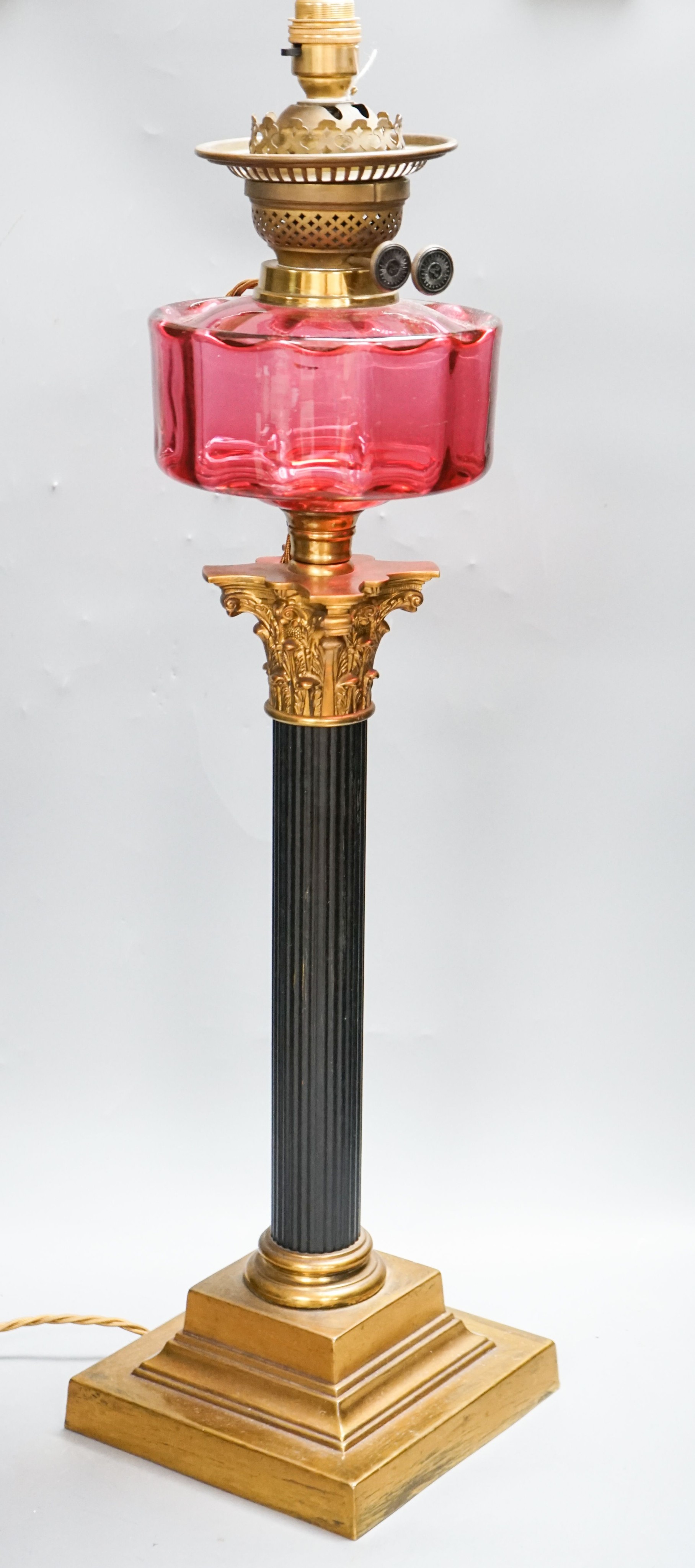 And early 20th century Corinthian column brass and cranberry glass oil lamp, converted for electricity, total height 70 cm